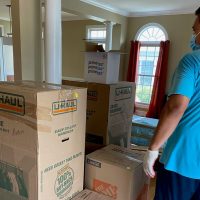 moving crew preparing brown moving box supplies before packing items for loading
