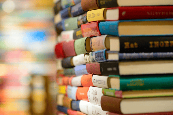 sorting-books-for-moving-mngmovers Stack of books being prepared for sorting before moving