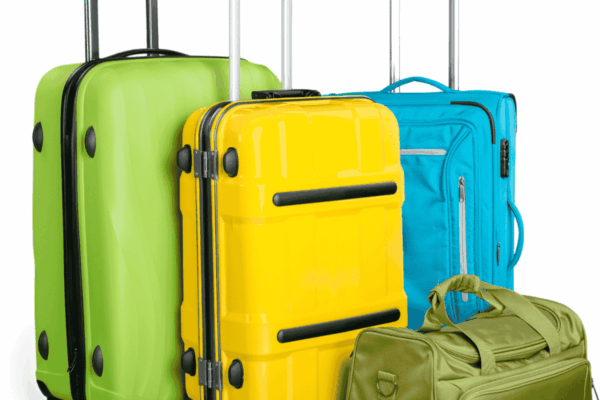 suitcase-sizes-for-moving-mngmovers Colorful travel suitcases and a duffel bag, including green, yellow, and blue luggage, standing upright and ready for packing or airport check-in.