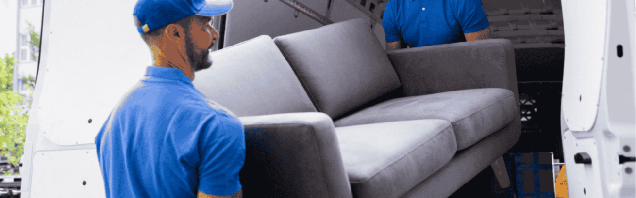 two men loading a sofa furniture in a truck