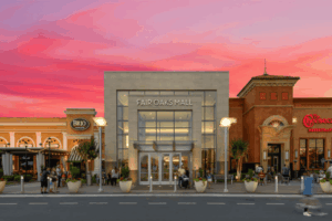 Fair Oaks Mall entrance in Fairfax VA with Brio and Cheesecake Factory restaurants under a vibrant pink sunset sky.