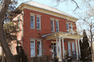 The Fairfax Museum and Visitor Center in a historic brick building surrounded by trees and spring blossoms in Fairfax VA.