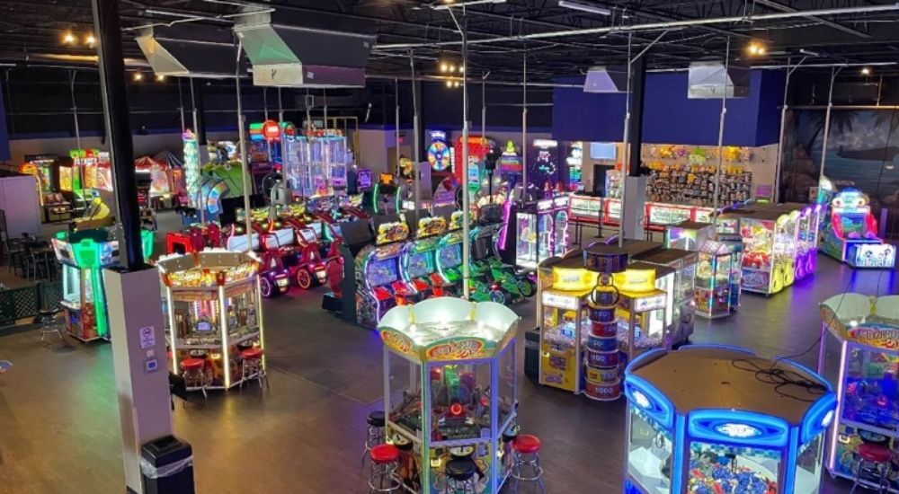 Colorful arcade games and claw machines fill Fun Land of Fairfax in Centreville, Virginia, under bright lights.