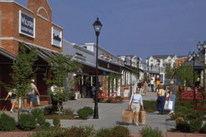 Shoppers walking through Leesburg Premium Outlets on a sunny day.