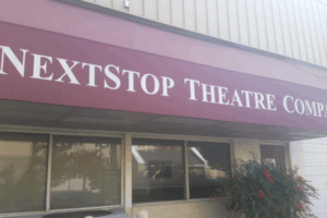 NextStop Theatre Company entrance in Herndon VA with bold maroon awning and white lettering, located in the heart of the arts district.